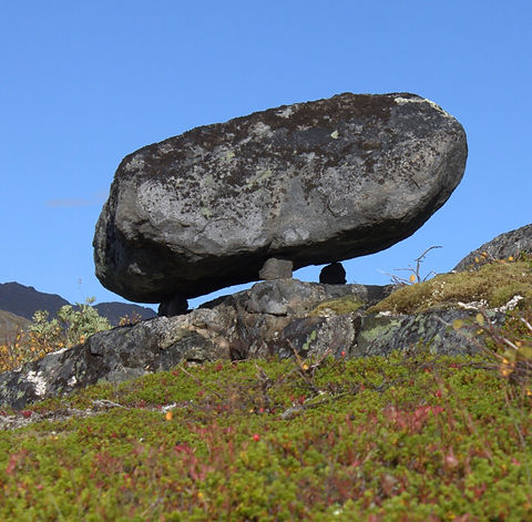 Stor stein balanserer på mindre steiner i fjellet